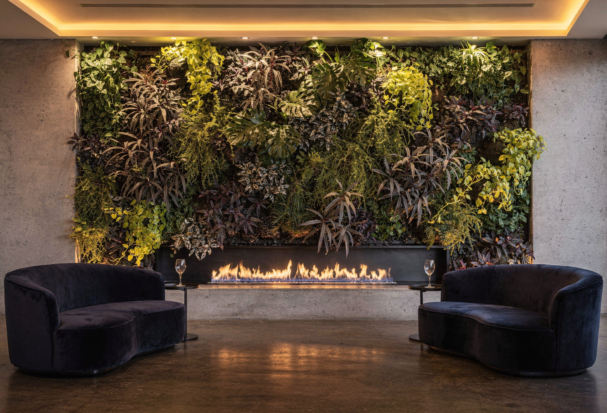 Akşam ışığında şömine arkasındaki aydınlatılmış yaşayan bitki duvarı